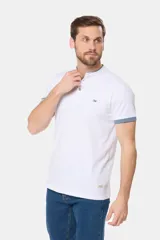 Remera de manga corta color azul grisáceo con cuello mao y tapeta de botones. Los puños de las mangas y el cuello son de color azul marino contrastante. Presenta un pequeño logo bordado en el pecho.