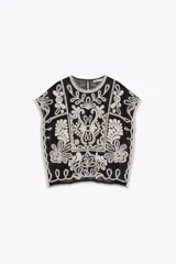 Top de Zara Woman Collection, color negro con apliques de crochet en color crudo. Cuello redondo y manga corta caída. Cierre en la espalda con abertura y botón.