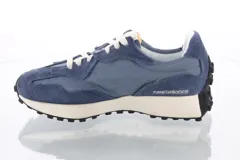 Championes urbanos New Balance, color azul con detalles en gris y blanco, confeccionados en gamuza y tela, con logo "N" característico en los laterales y suela de goma.