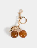 Llavero con dije de cerezas color marrón con glitter dorado, hojas doradas y mosquetón metálico dorado.