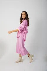 Pantalón capri color beige, de tejido acanalado, con cintura elástica y bolsillos laterales.