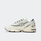 Championes New Balance modelo M1000, color crema con detalles en gris, confeccionados en cuero y malla, con logo "N" característico en los laterales y suela segmentada con amortiguación ABZORB.