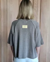 Buzo de punto color verde kiwi con cuello, puños y ruedo en azul.