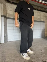 Pantalón de jean negro de corte ancho con costuras reforzadas en las rodillas.