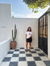 Minifalda dorada de cuero sintético, corte medio/bajo, con cortes en el delantero y pequeño tajo a un lado.