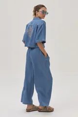 Pantalón de jean celeste de corte ancho, con cintura alta y lazo ajustable.