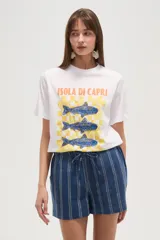 Remera blanca de algodón con cuello redondo y mangas cortas. Estampado frontal con diseño de peces azules sobre fondo a cuadros amarillos y texto "Isola di Capri" y "Amalfi Coast".