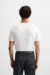 Camiseta slim fit de cuello redondo y manga corta, confeccionada en tejido de algodón con elasticidad.