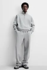 Pantalón jogger gris de corte recto, confeccionado en tejido de algodón compacto con interior en rizo. Cuenta con cintura elástica ajustable con cordón interior, bolsillos frontales y bolsillo de doble vivo en la espalda.