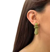 Aros colgantes con forma de lágrima, hechos de hilo verde enrollado.