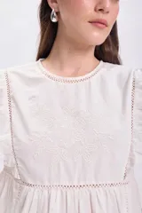 Vestido corto color crudo, de estilo boho, con bordados y mangas cortas con volados.