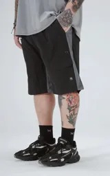 Bermuda deportiva color negro con paneles laterales grises. Presenta cintura elástica con cordón de ajuste estampado, bolsillos laterales y un bolsillo cargo con solapa en el muslo derecho.