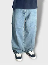Pantalón jean celeste de corte mega baggy, estilo carpintero, con presillas para cinturón y bolsillos laterales.