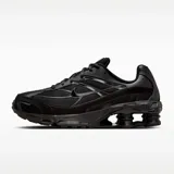 Zapatilla deportiva Nike Shox Ride 2, completamente negra, con capellada de malla y superposiciones sintéticas brillantes. Presenta la tecnología de amortiguación Nike Shox en el talón y detalles de Swoosh en los laterales.