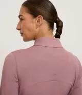 Campera deportiva negra de manga larga y cuello alto, con cierre frontal. Presenta recortes en el torso y bolsillos laterales con cierre.