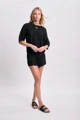 Top de punto crochet color negro con mangas cortas y cuello redondo.