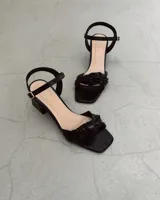 Sandalia plateada de cuero vacuno con taco cuadrado de 6 cm y tira delantera con nudo.