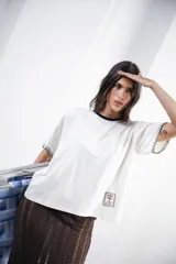 Remera azul marino de algodón con cuello redondo blanco y mangas cortas con bordado blanco.