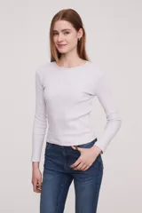 Remera de algodón color marfil, ajustada al cuerpo y de manga larga con cuello redondo.