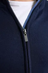 Cardigan azul de tejido de punto con cierre frontal y cuello alto.