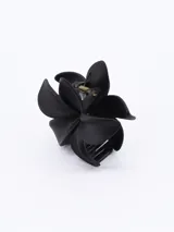 Pinza para el pelo negra con forma de flor de cinco pétalos.