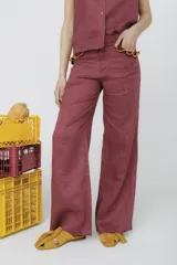Pantalón de vestir color ladrillo, de corte palazzo y cintura alta. Presenta detalle de volados en los bolsillos delanteros.