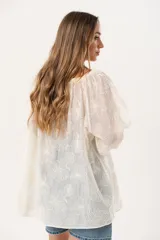 Blusa color crudo con bordado de flores, escote cuadrado y mangas 3/4 abullonadas.