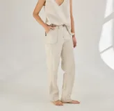Pantalón largo color beige de lino, con bolsillos delanteros y traseros, cierre con botón y presillas para cinturón.