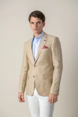 Saco de lino color beige, corte slim fit, con solapa de muesca, cierre de dos botones, bolsillo en el pecho y dos bolsillos delanteros con solapa. Medio forro.
