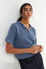 Remera tejida color celeste con cuello polo y mangas cortas. Tejido calado con trama abierta.