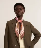 Pañuelo cuadrado de satén con estampado de motivos playeros en tonos rosados, marrones y blancos.