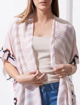 Kimono tejido con estampado abstracto en tonos beige, blanco y negro. Tiene mangas amplias estilo japonés y terminación de ruedo con borlas.