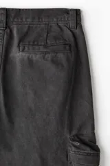 Pantalón cargo negro de corte recto, con múltiples bolsillos con cierre y botón.