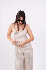 Mono largo color beige con rayas verticales negras, breteles finos, escote en V y lazo en la cintura.