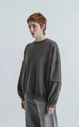 Buzo cuello redondo color gris oscuro con efecto desgastado, costuras expuestas y calce oversize crop.