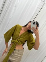 Top de lino color crudo con mangas amplias y lazo versátil para atar al frente o cruzarlo y ajustarlo atrás.