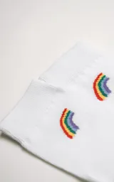 Medias blancas de algodón con puño acanalado y logo de la marca en el tobillo. Presentan un pequeño arcoíris bordado en el lateral.
