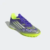 Championes de fútbol Adidas F50 League Turf Cleats, color violeta con detalles en amarillo y blanco. Diseñados para césped artificial.