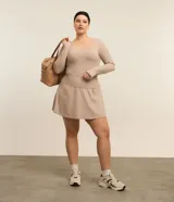 Short pollera deportivo color beige, confeccionado en microfibra ligera, con cintura ancha y calza interna.