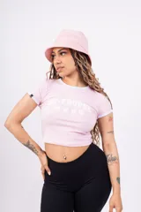 Remera corta de jersey color rosa con cuello redondo y mangas cortas con ribete blanco. Estampado frontal con la inscripción "ST-TROPEZ" en letras blancas.