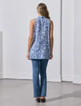 Blusa sin mangas estampada en blanco y azul, con escote en V, pliegue delantero y tajo en costuras laterales.