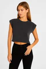 Remera cropped negra de algodón con cuello redondo y sisas amplias.