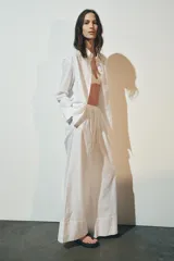 Pantalón palazzo blanco de lino, de tiro alto con cintura elástica ajustable con lazada.