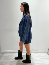 Blazer azul marino con rayas verticales blancas, confeccionado en lino italiano. Tiene botones de coco, solapas clásicas y bolsillos delanteros.