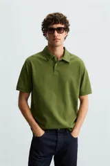 Polo de piqué color crudo, corte regular fit, cuello solapa con cierre de botonadura y mangas cortas.