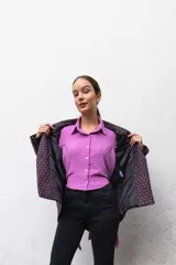 Camisa manga larga color beige con textura plumetie, abotonada en el pecho y lazo regulable que permite múltiples usos.