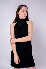 Minivestido negro con cuello alto drapeado y espalda descubierta.