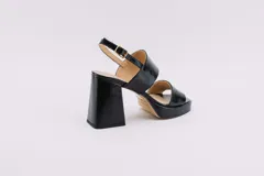 Sandalias de plataforma color borgoña, confeccionadas en charol. Tienen dos tiras anchas sobre el empeine, pulsera con hebilla al tobillo y taco cuadrado de 9 cm.