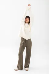 Pantalón tejido color blanco, de corte amplio y tiro alto, con bolsillos laterales y cintura con cordón ajustable.