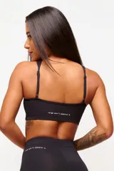 Top deportivo negro con cuello halter y espalda descubierta. Confeccionado en poliamida y elastano con protección UV50+.